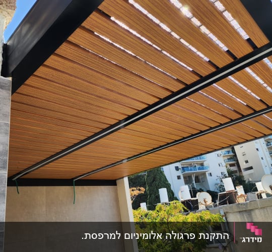 פרגולה מאלומיניום עם קירוי עץ במרפסת
